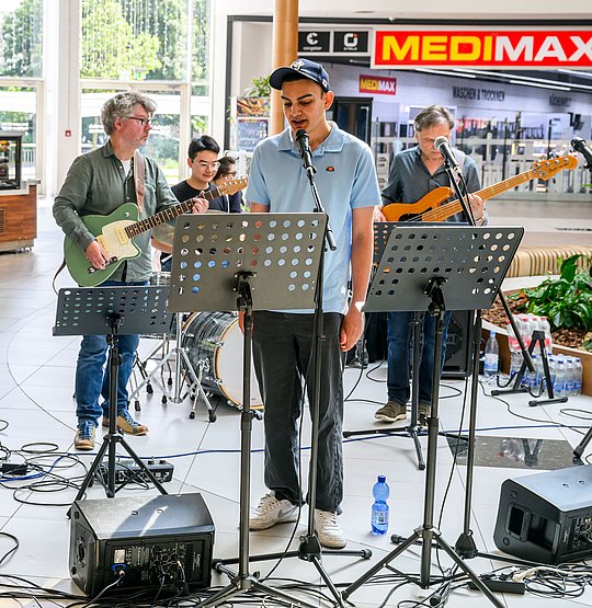 4 Musiker mit Gitarren, im Vordergrund en Sänger